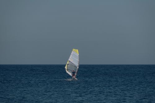 Free A windsurfer enjoying the open sea off the coast of Avola, Sicily on a clear summer day. Stock Photo