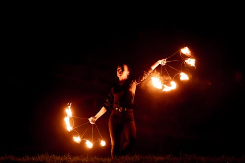 Woman in Black and White Shirt Holding Fire