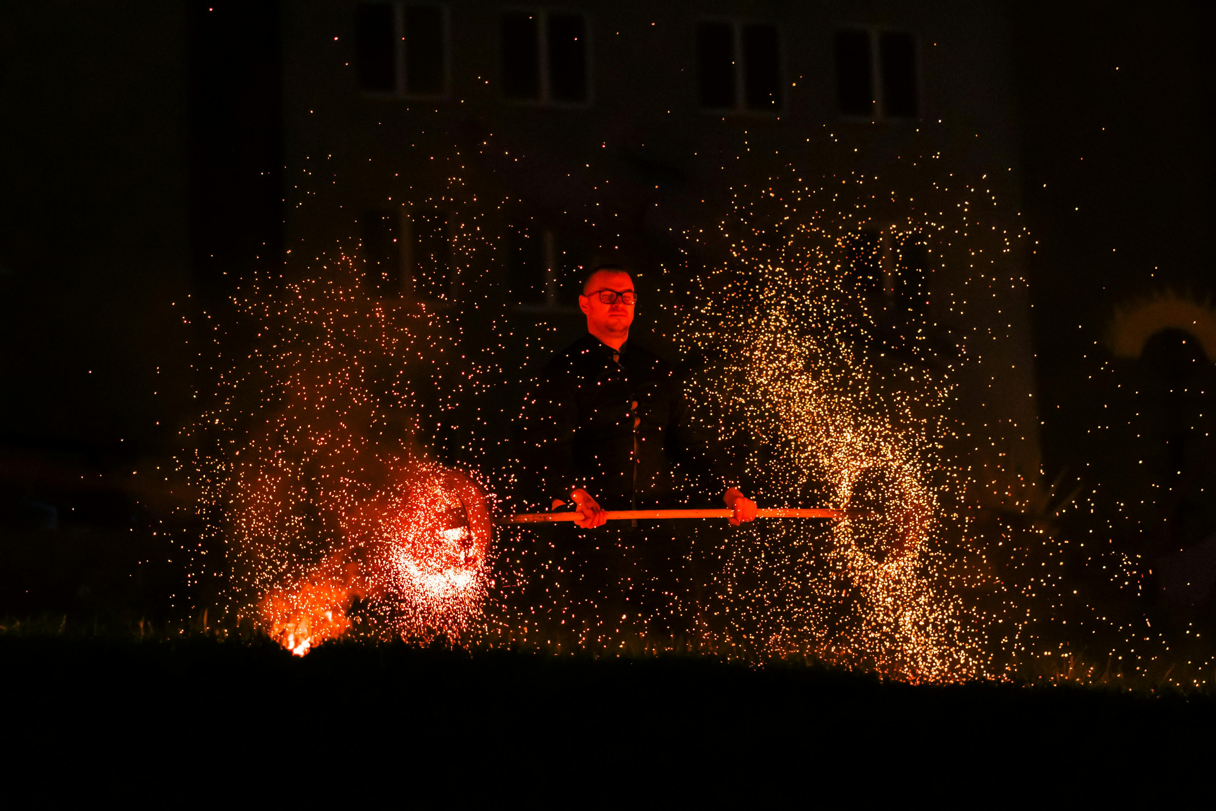 man in red hoodie standing on black surface with water splash