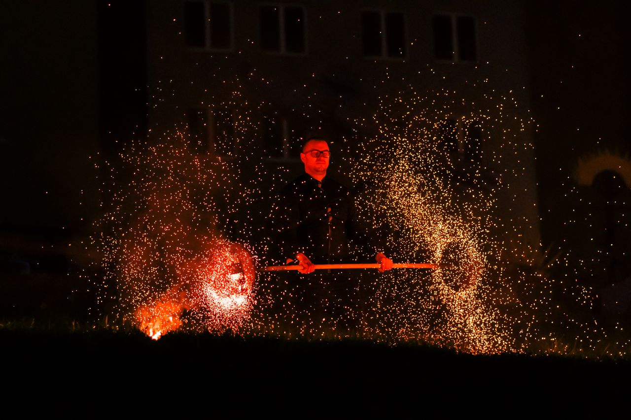 a mesmerizing fire performance with sparks illuminating the night high