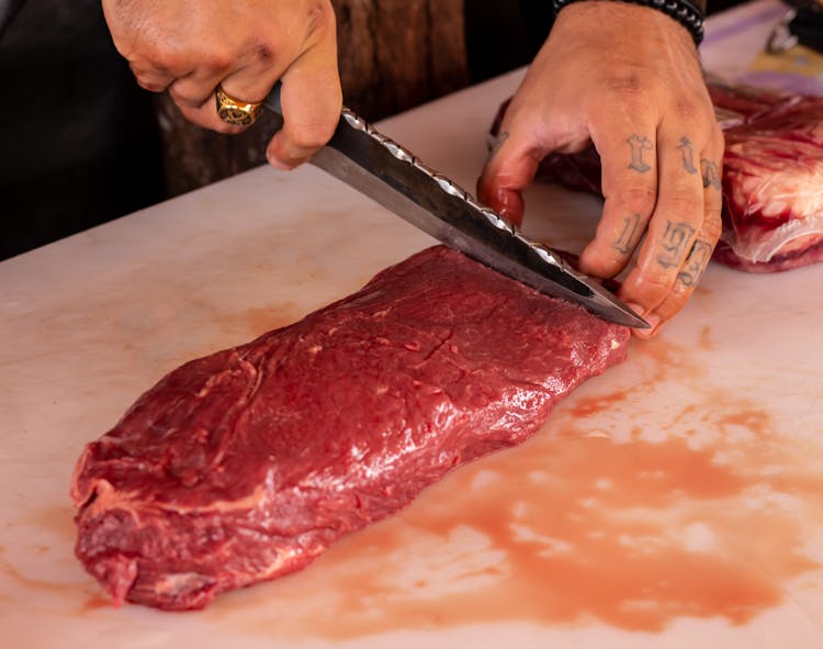 A Person Slicing Raw Meat