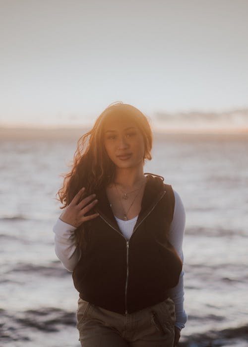 Woman Wearing a Vest Over White Long Sleeve Shirt