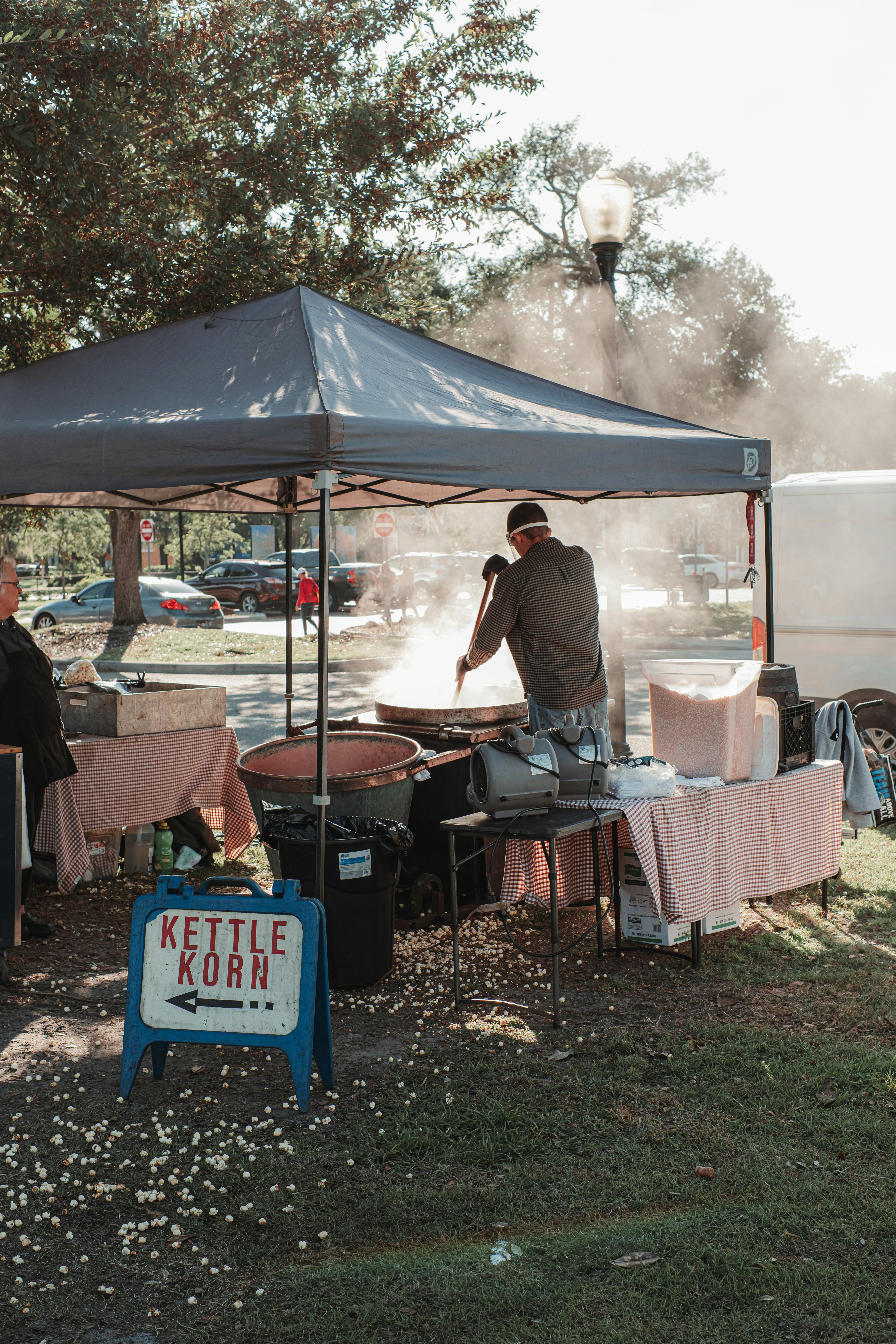 man in white t shirt and black pants cooking on outdoor grill