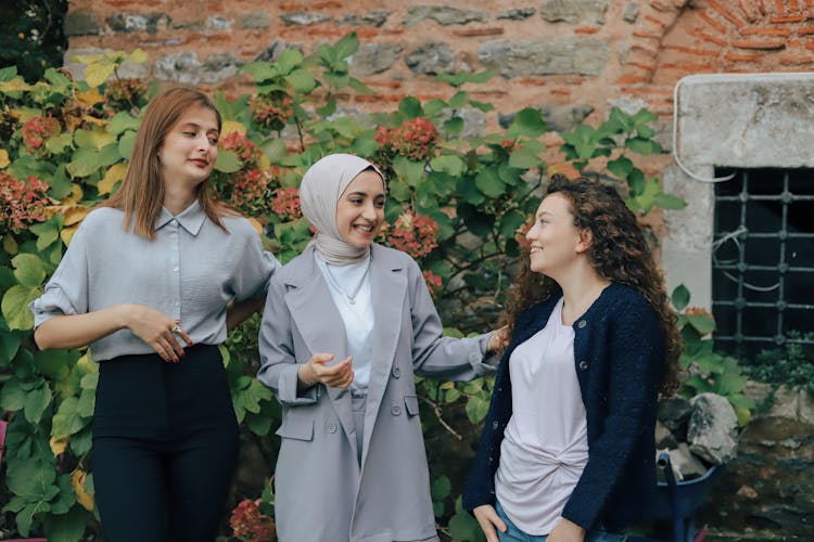 Girls Standing Near Green Plants