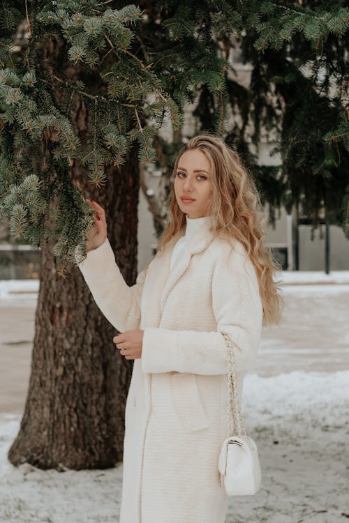 Woman in a Winter Coat Standing by a Tree 