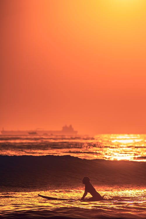 Silhouette of a Person Surfing on the Ocean Waves