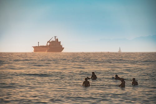 Silhouette of People Swimming in the Sea