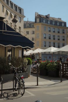 Sunny day in Paris with quaint cafes and classic architecture in view.