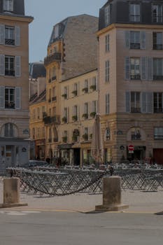 Charming street view of historic Parisian architecture in a sunny, urban setting.