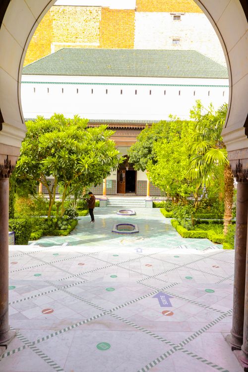 Free A serene courtyard with lush greenery and Moroccan-inspired architecture in Paris, France. Stock Photo