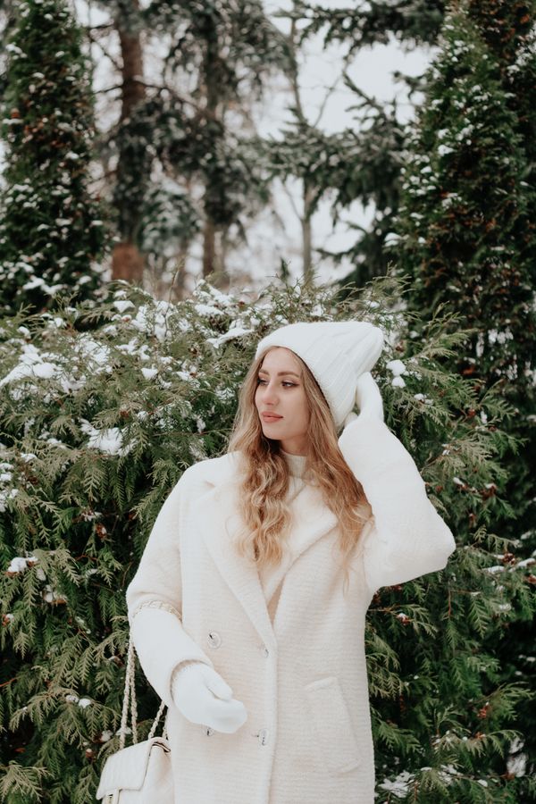 Woman in white wool coat over all-white outfit