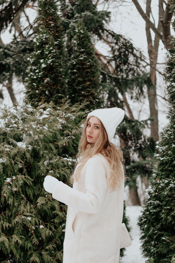 Woman in ivory wrap wool coat over white sweater dress