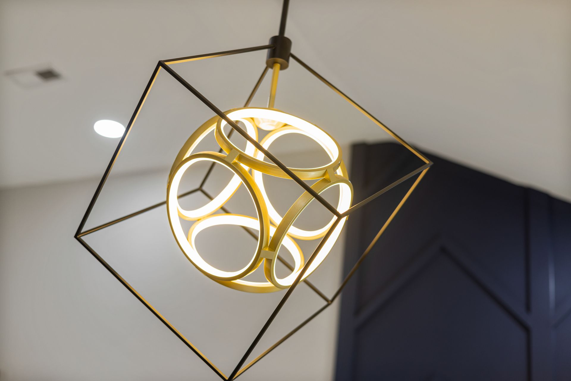 A modern geometric ceiling light fixture with gold accents, perfect for luxurious indoor spaces.