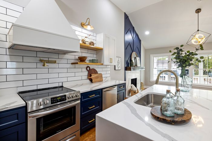 Renovated kitchen with marble countertops and blue cabinets