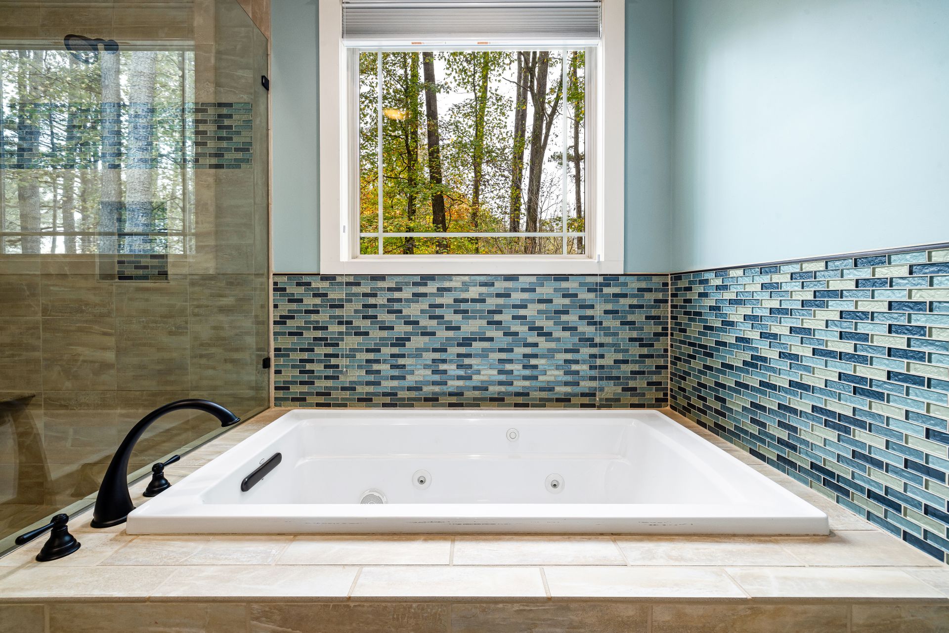 Luxurious modern bathroom featuring a jacuzzi tub and stylish tile design.
