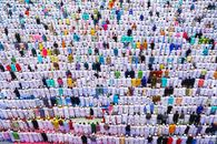Aerial view of a large group of Muslims in traditional attire gathered for prayer in Howrah, India.