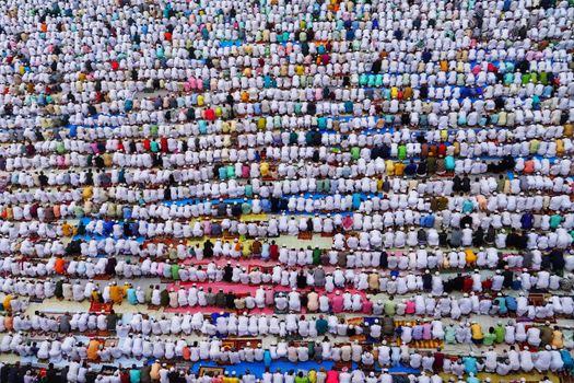 Aerial image of a large group of people praying in rows, capturing the essence of community worship in Howrah, India.