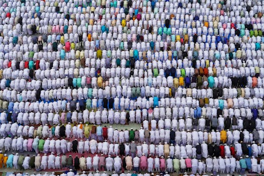 Aerial shot capturing a large group of people in traditional attire performing a prayer in Howrah, India.