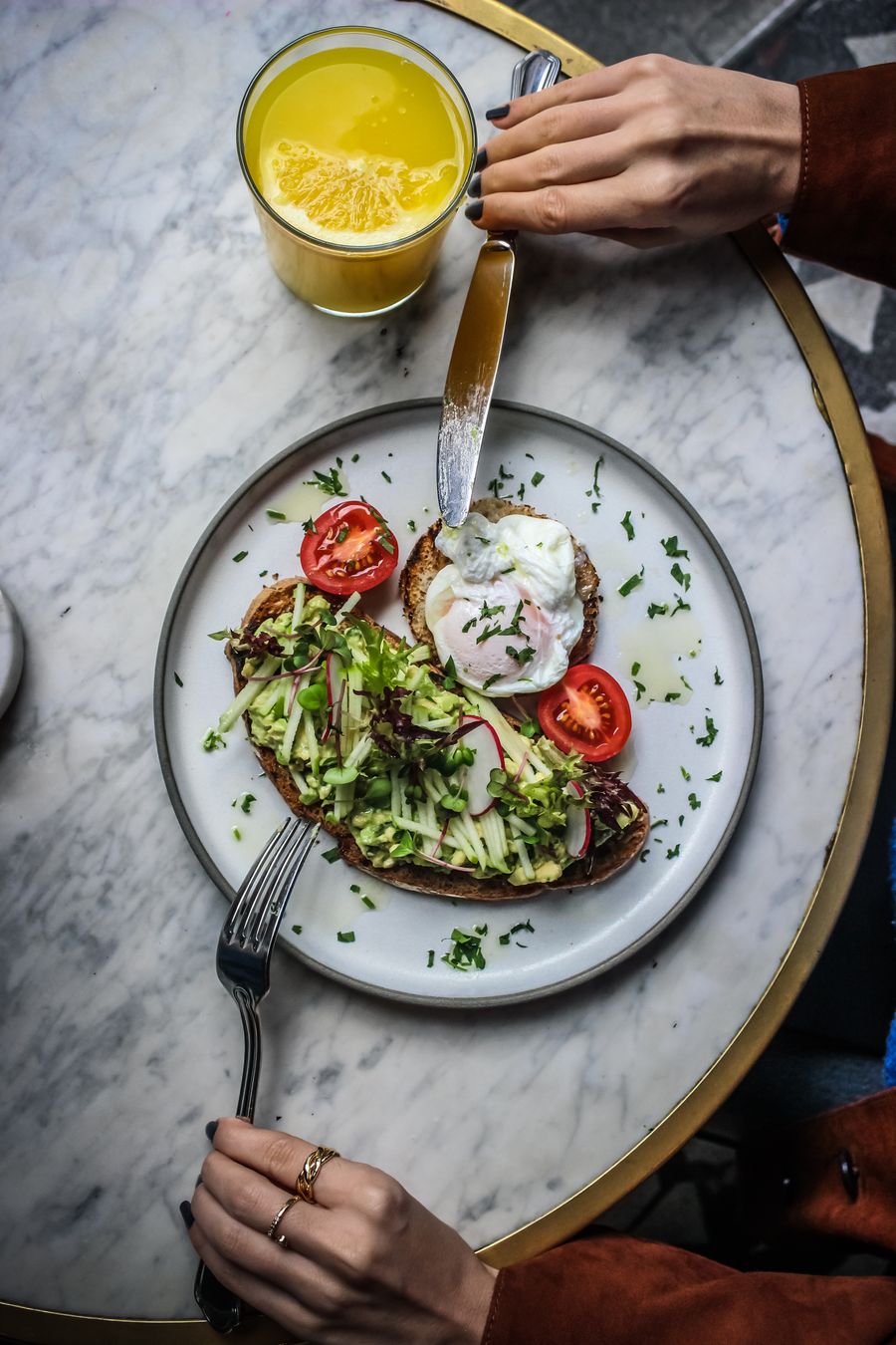 Avocado-Toast mit pochiertem Ei und frischem Orangensaft, von oben