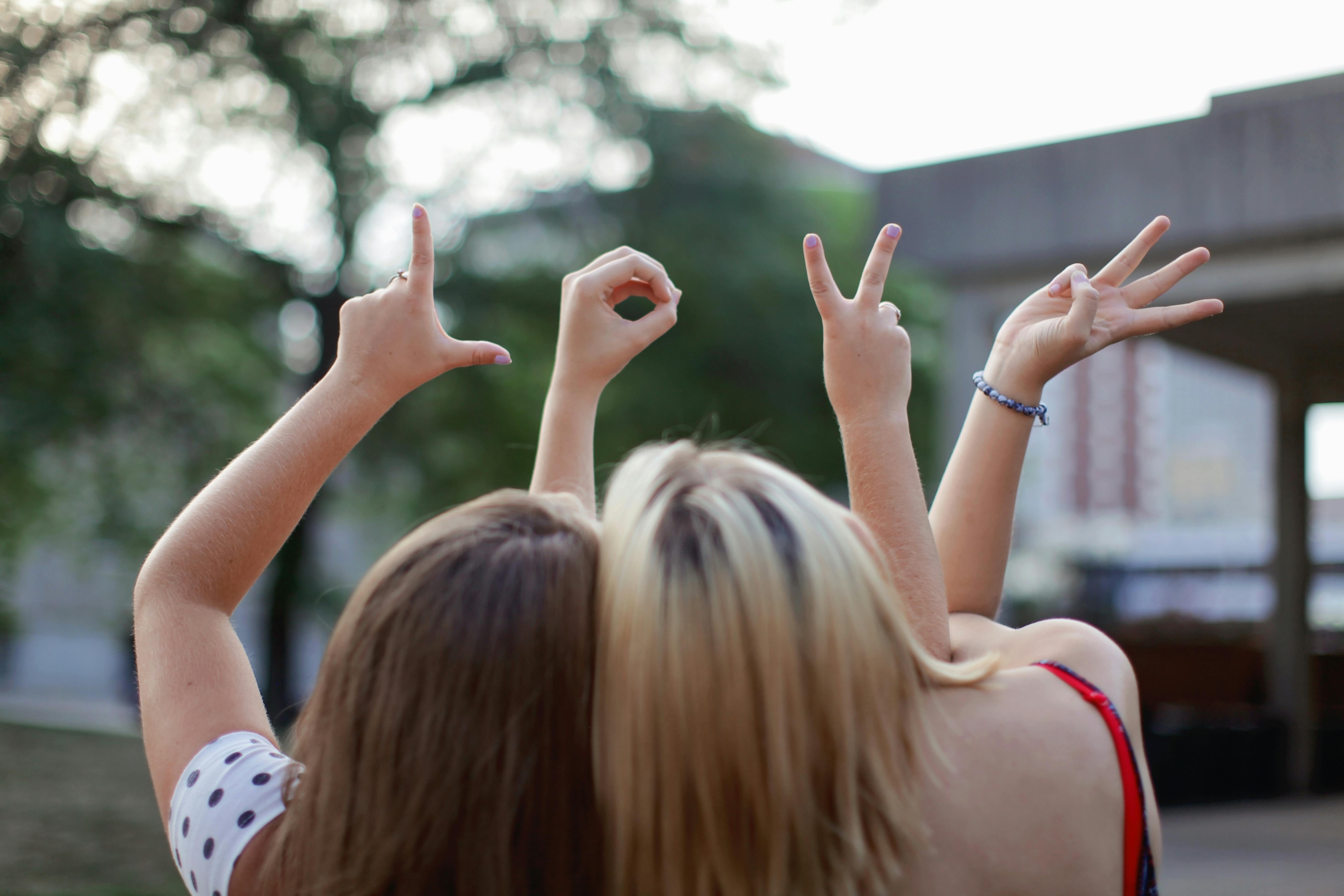 photo-of-four-girls-wearing-school-uniform-doing-hand-signs-free-stock-photo