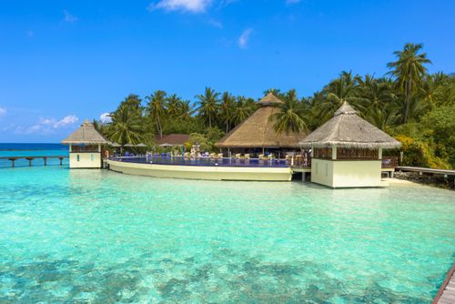 Free Stunning tropical beach resort with bungalows over turquoise waters, perfect for a relaxing getaway. Stock Photo