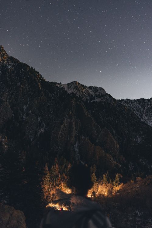Free Beautiful starry night sky with mountain landscape and forest in view. Stock Photo