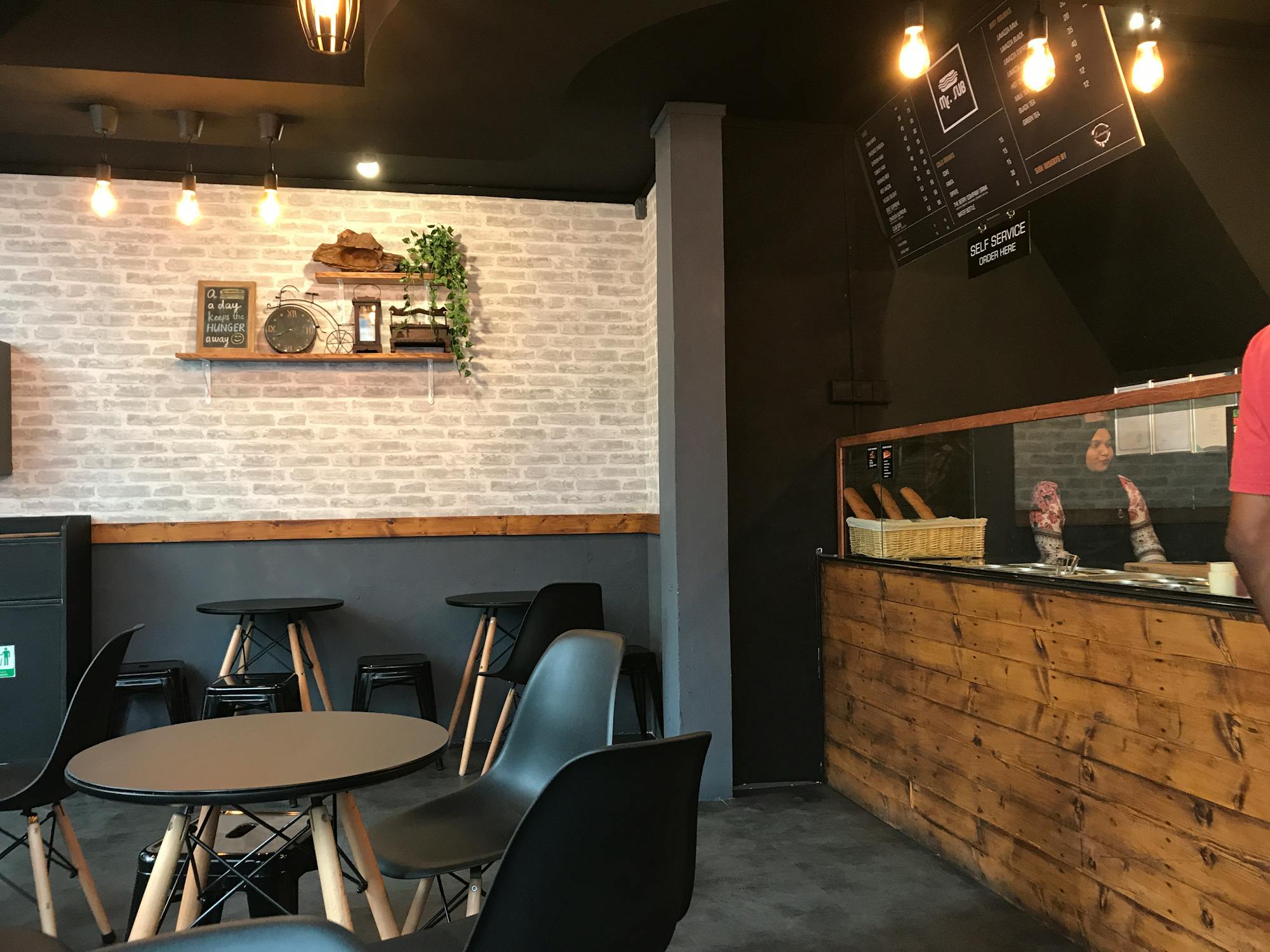 Ein zufriedener Restaurantbesitzer steht lächelnd in seinem Lokal.