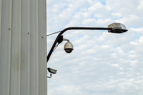 Street Lamp and Surveillance Camera Beside a Wall