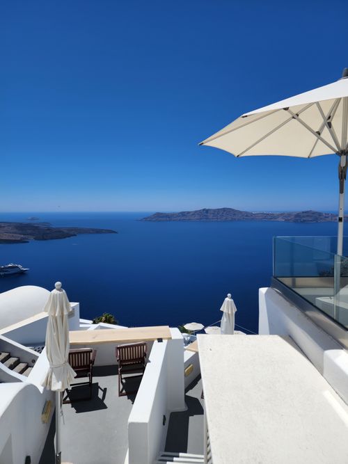 Free A stunning view of a luxury terrace in Santorini with umbrellas and sea view. Stock Photo