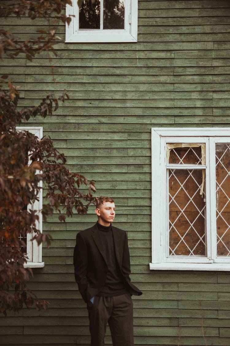 Portrait Of A Man Standing In Front Of A House