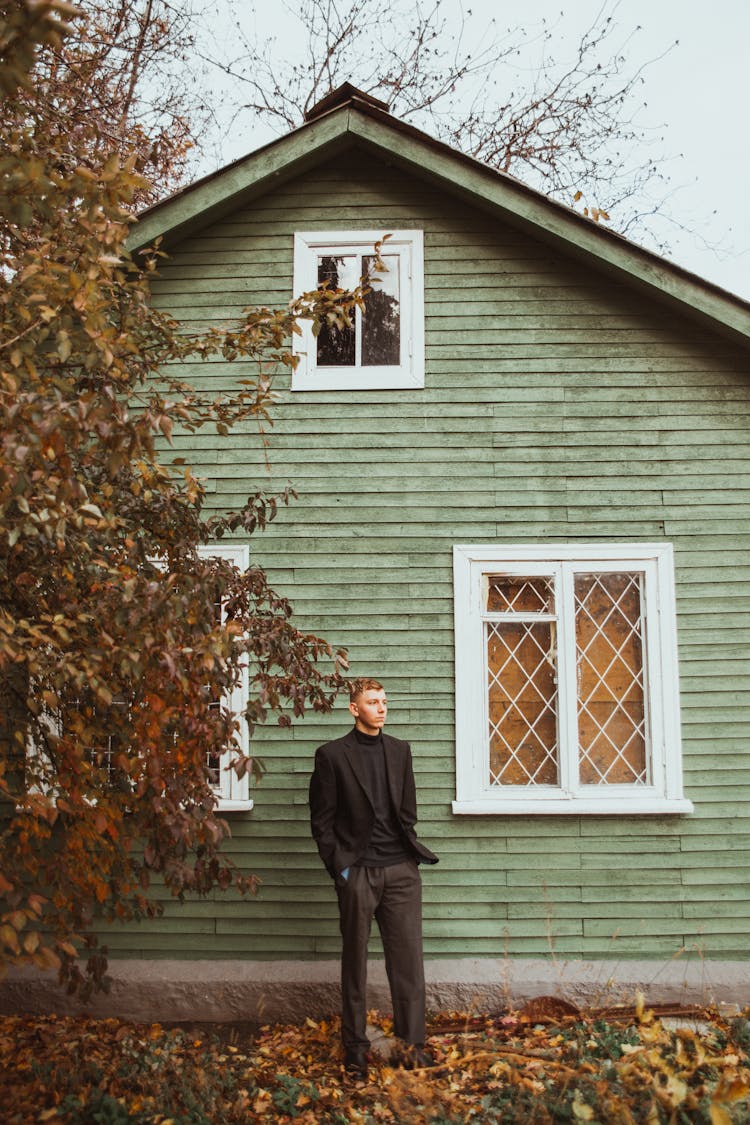 A Man Standing In Front Of A House