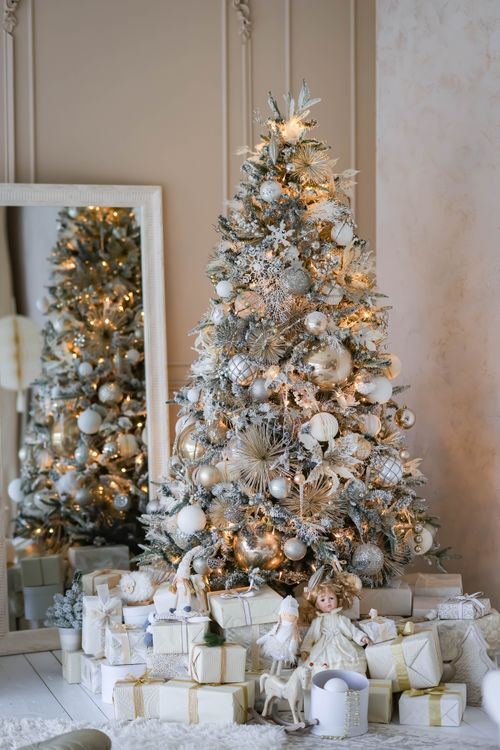Free A beautifully decorated Christmas tree with gifts and holiday decorations inside a cozy home. Stock Photo