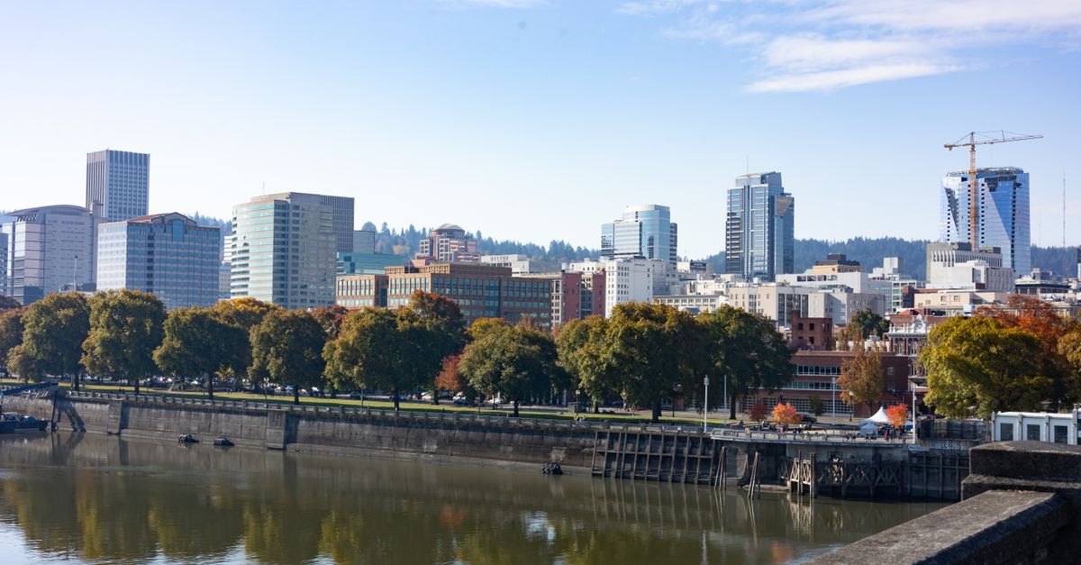 Stunning view of Portland's skyline reflected on the tranquil waterfront on a sunny day.