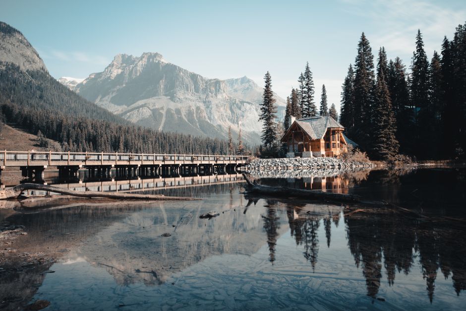 Beautiful lodge with bridge and mountains reflecting in Emerald Lake, BC.
