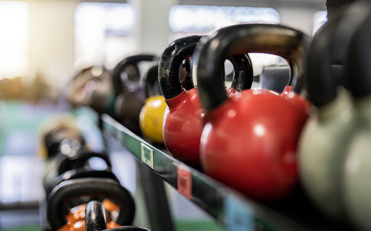 Close-up of colorful kettlebells on a rack in a modern gym indoors.
