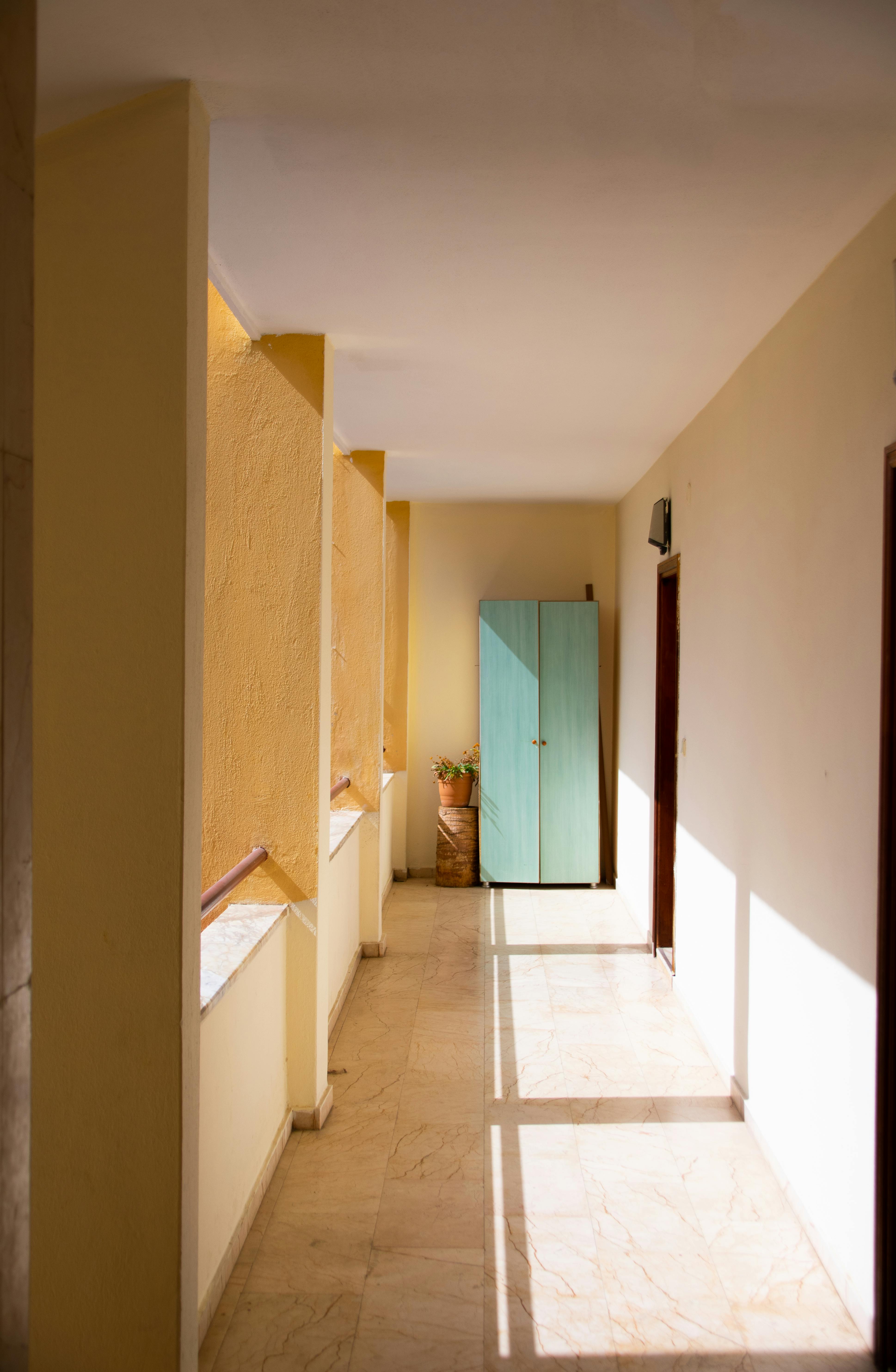 Bright hallway with sunlight casting shadows on marble floor in Antalya.