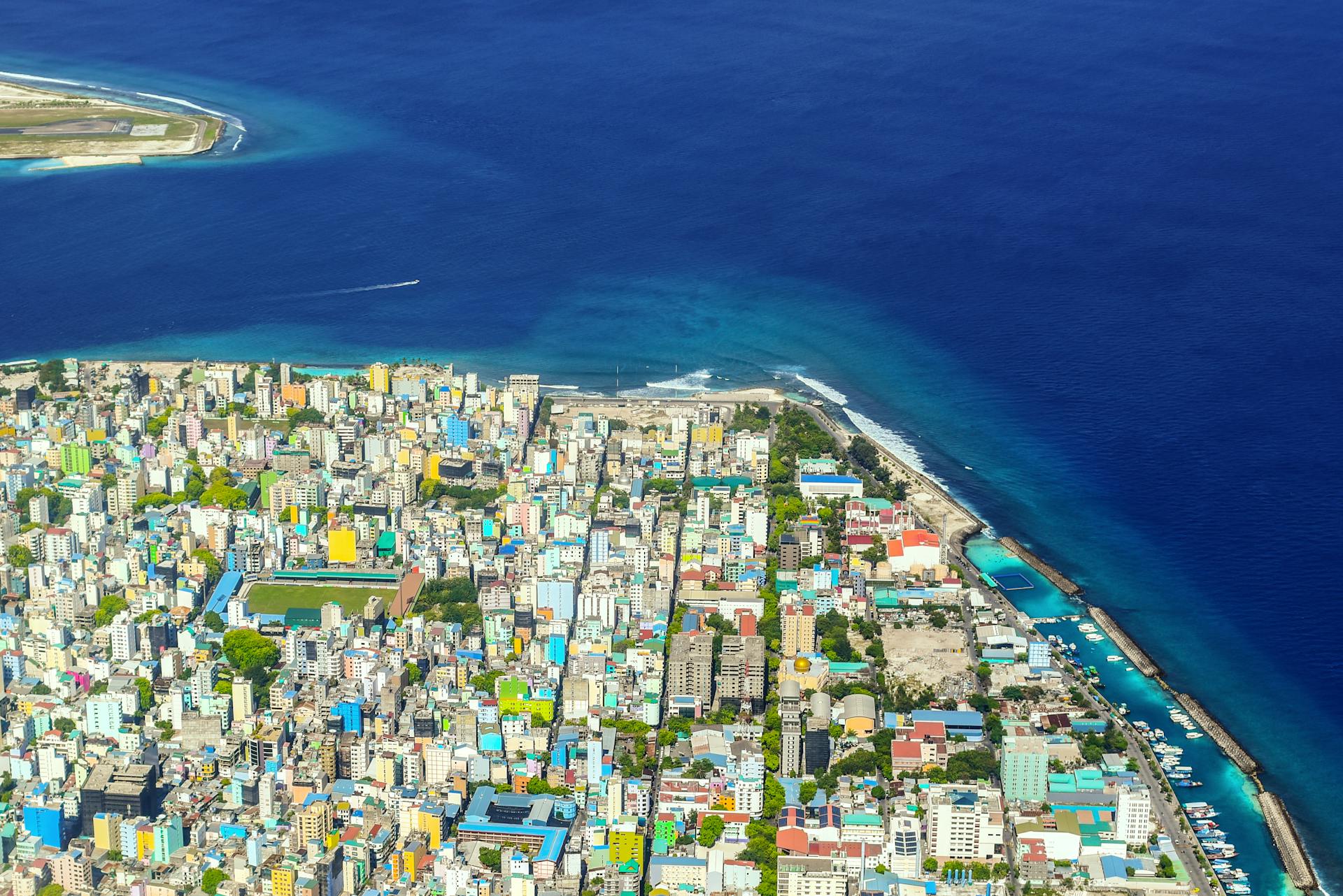 Explore a colorful coastal city adjacent to the vast ocean from a captivating aerial perspective.