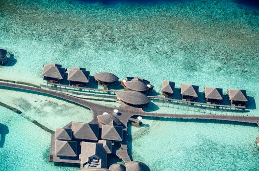 Stunning aerial shot of overwater bungalows on turquoise waters in a tropical paradise.