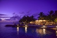 黄昏时分，热带度假村被棕榈树环绕，壮丽的景色映照着大海