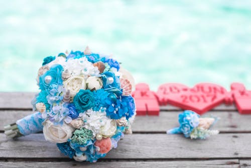 Free Bouquet of Blue and White Flowers on Top of Brown Surface Stock Photo