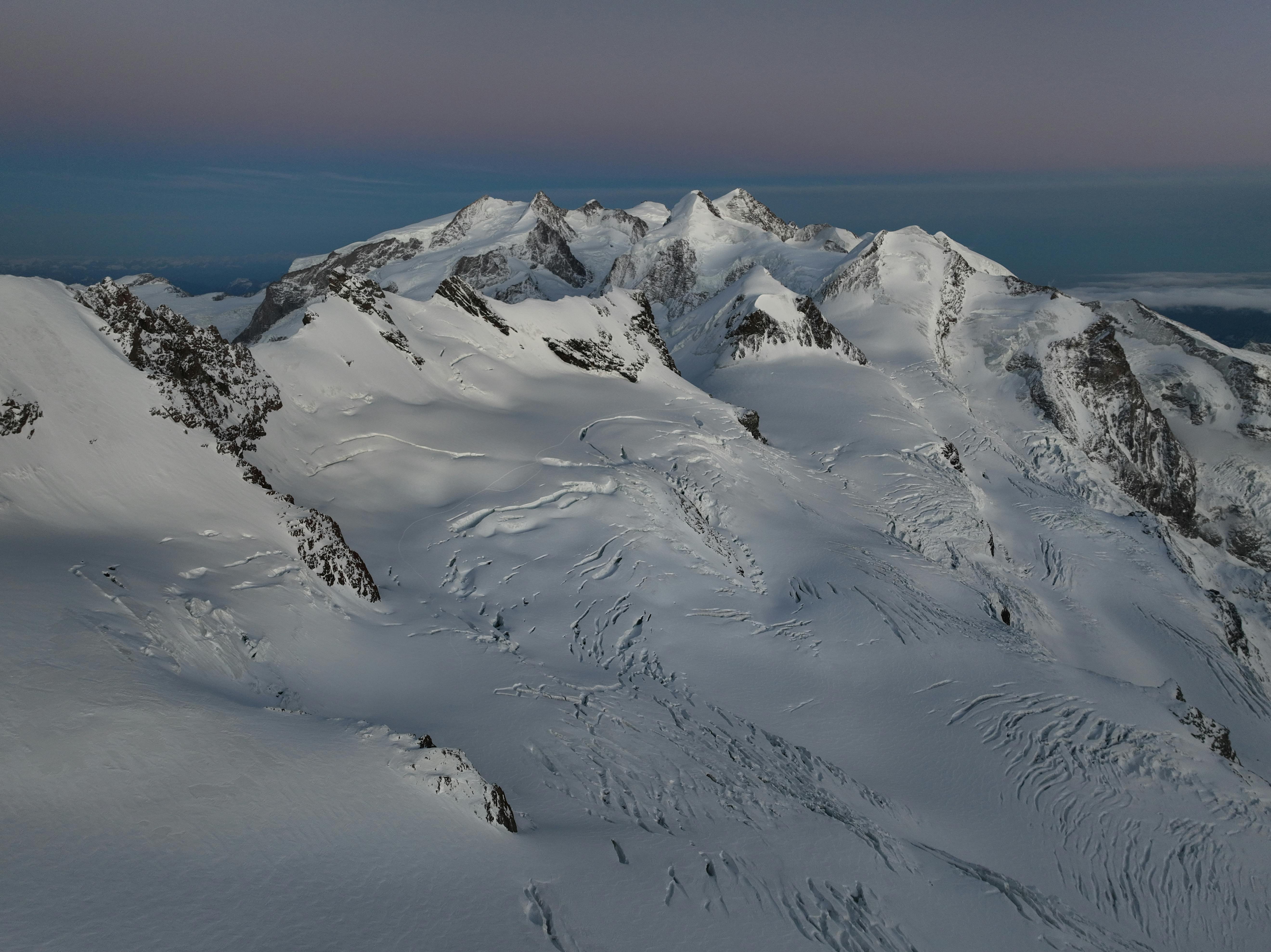 A stunning aerial shot of snow-covered Swiss Alps peaks during winter in Zermatt, Switzerland.
