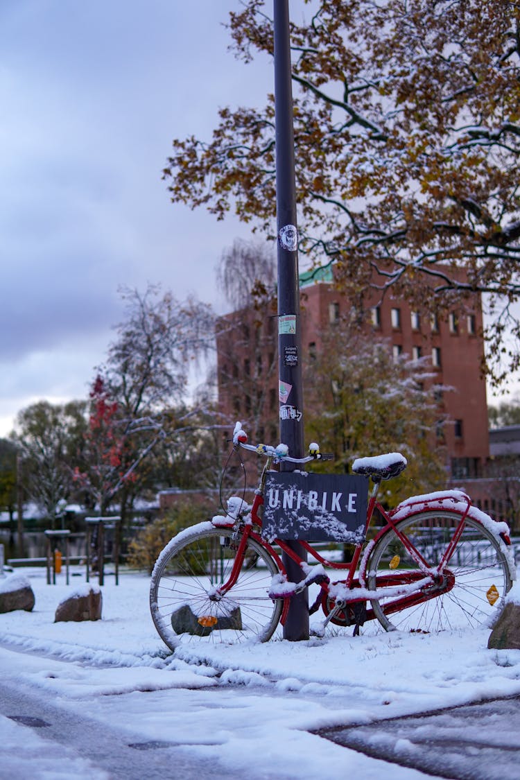 Bicycle In Snow Near Sidewalk