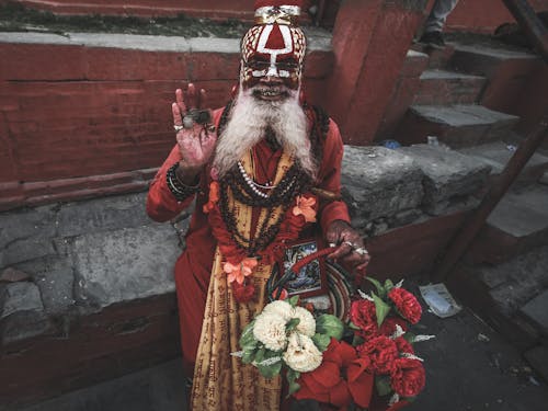 Man in Traditional Clothing with Flowers and Painted Face