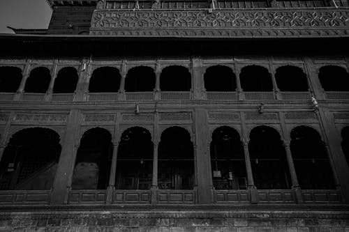 Grayscale Photo of Concrete Building with Arched Columns