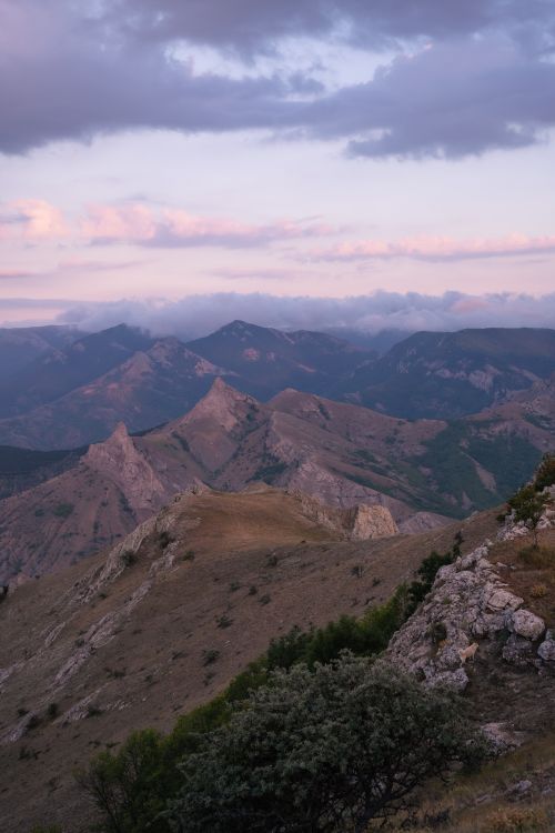 Free Breathtaking aerial view of rocky mountain landscape during pink sunset, perfect for nature and travel enthusiasts. Stock Photo