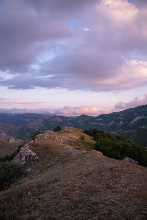 Free Tranquil mountain scene with lush greenery and dramatic skies at twilight. Stock Photo