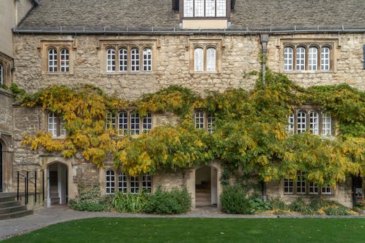 Charming ivy-covered stone facade of an Oxford historic building with traditional windows.