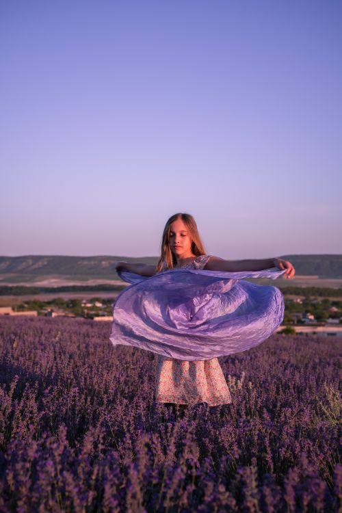 Free A young girl in a lavender field at sunset, twirling gracefully in a light dress. Stock Photo