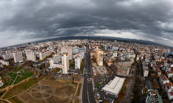 Dramatic aerial view of Sofia, Bulgaria showcasing urban architecture beneath cloudy skies.