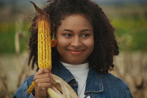 Close Up Photo of Woman Holding a Corn